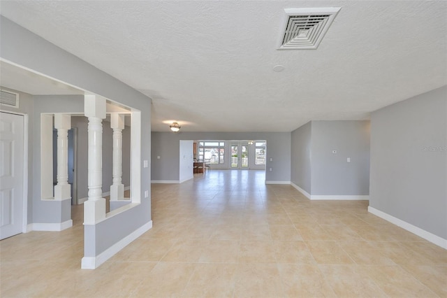 710 116th Ave, Treasure Island, FL 33706 - unfurnished room featuring baseboards, light tile patterned flooring, and a textured ceiling