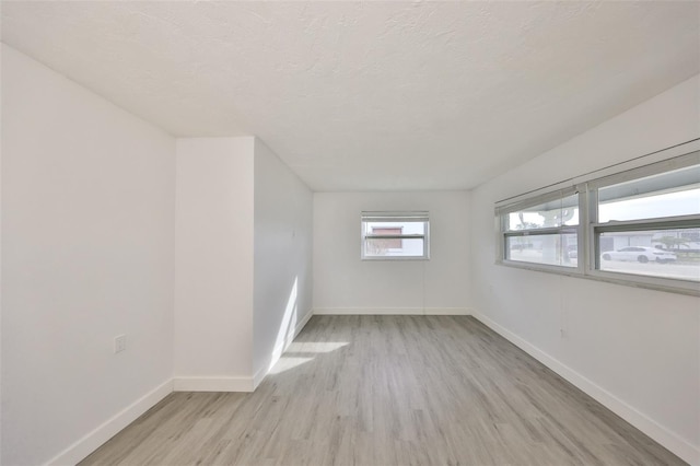 710 116th Ave, Treasure Island, FL 33706 - unfurnished room featuring light wood-type flooring, baseboards, and a textured ceiling