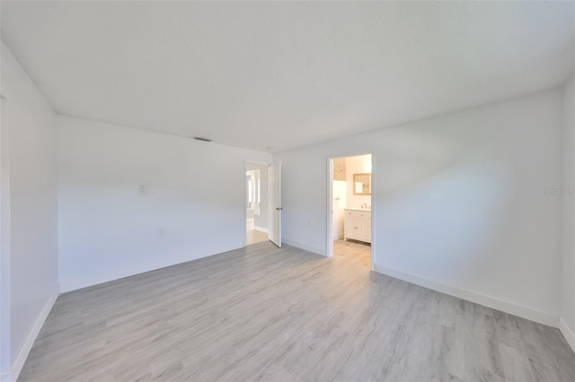 710 116th Ave, Treasure Island, FL 33706 - empty room with light wood-type flooring and baseboards