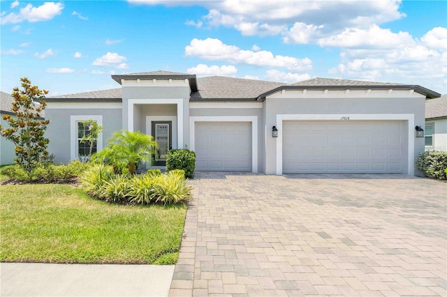 17618 Cortes Creek Blvd, Spring Hill, FL 34610 - prairie-style house featuring an attached garage, decorative driveway, stucco siding, and a front yard