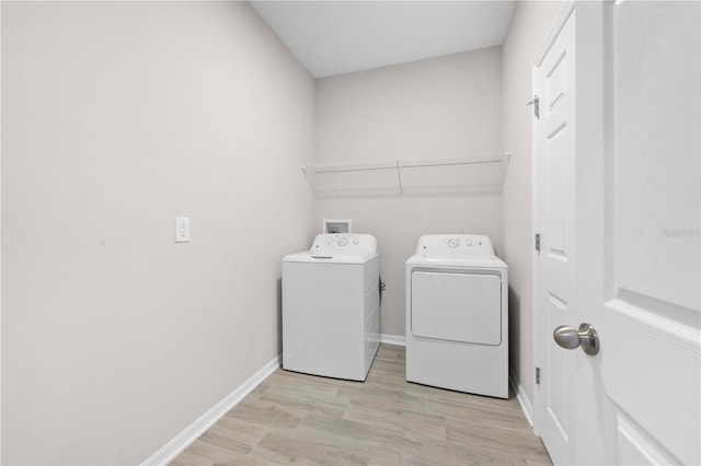 17618 Cortes Creek Blvd, Spring Hill, FL 34610 - washroom with washing machine and clothes dryer, baseboards, and light wood-style floors