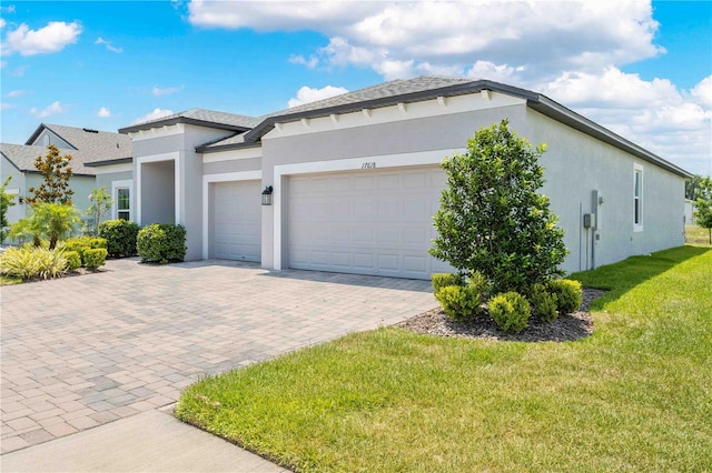 17618 Cortes Creek Blvd, Spring Hill, FL 34610 - view of front facade featuring stucco siding, a front lawn, an attached garage, and decorative driveway