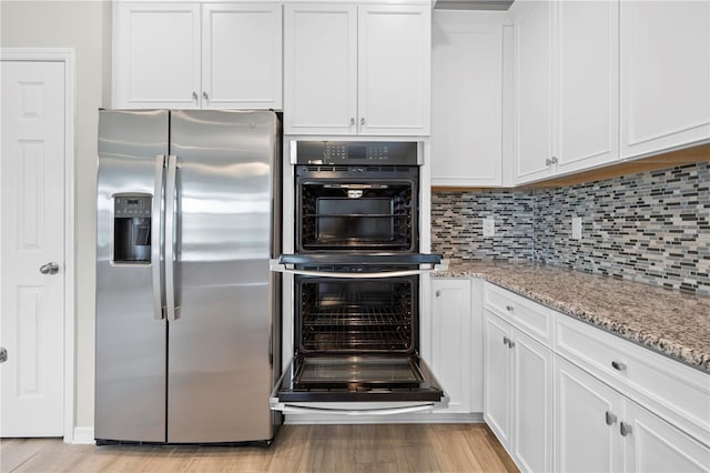 17618 Cortes Creek Blvd, Spring Hill, FL 34610 - kitchen featuring stainless steel fridge, light wood-style floors, white cabinets, light stone countertops, and decorative backsplash