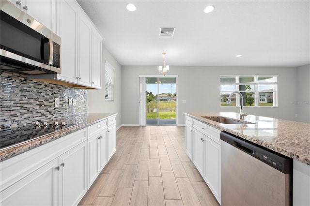 17618 Cortes Creek Blvd, Spring Hill, FL 34610 - kitchen featuring stainless steel appliances, a sink, tasteful backsplash, baseboards, and white cabinets