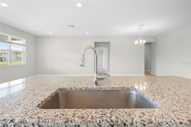 17618 Cortes Creek Blvd, Spring Hill, FL 34610 - kitchen with a sink, a chandelier, light stone counters, recessed lighting, and decorative light fixtures