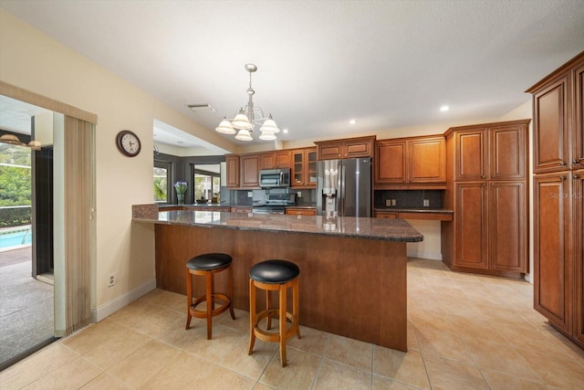 14175 Feather Sound Dr, Clearwater, FL 33762 - kitchen with stainless steel appliances, brown cabinetry, a breakfast bar, glass insert cabinets, and light tile patterned floors