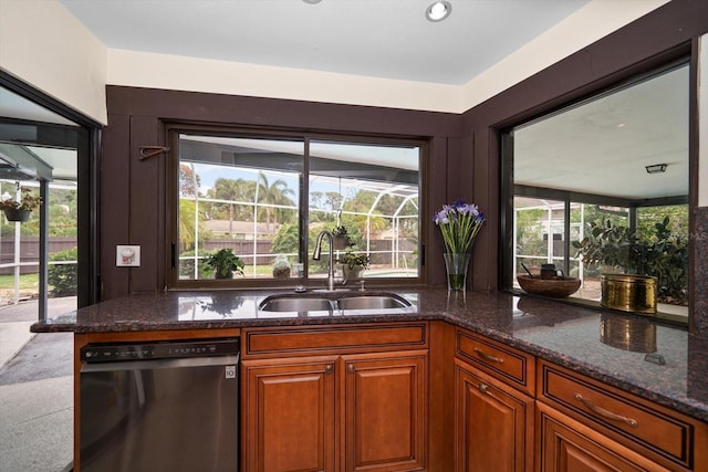 14175 Feather Sound Dr, Clearwater, FL 33762 - kitchen with dishwashing machine, a sink, dark stone counters, brown cabinetry, and healthy amount of natural light