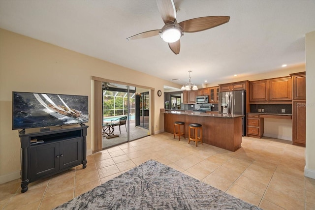 14175 Feather Sound Dr, Clearwater, FL 33762 - kitchen featuring stainless steel appliances, a ceiling fan, a peninsula, glass insert cabinets, and brown cabinetry