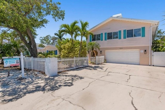 1210 Bay Pine Blvd, Indian Rocks Beach, FL 33785 - view of front facade featuring a garage, driveway, stucco siding, and a gate
