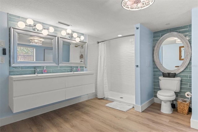 1210 Bay Pine Blvd, Indian Rocks Beach, FL 33785 - bathroom with toilet, a tile shower, wood finished floors, tile walls, and vanity