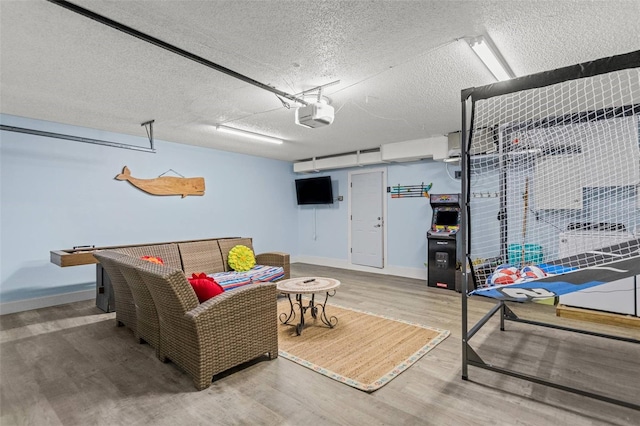 1210 Bay Pine Blvd, Indian Rocks Beach, FL 33785 - recreation room with a garage, wood finished floors, a textured ceiling, and baseboards