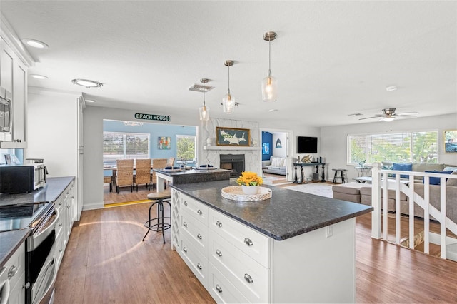 1210 Bay Pine Blvd, Indian Rocks Beach, FL 33785 - kitchen featuring appliances with stainless steel finishes, wood finished floors, open floor plan, and recessed lighting