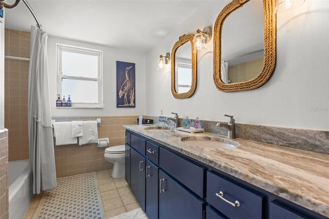 1210 Bay Pine Blvd, Indian Rocks Beach, FL 33785 - full bath featuring double vanity, tile patterned flooring, toilet, shower / tub combo with curtain, and tile walls