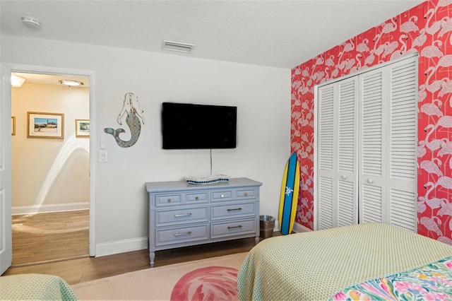 1210 Bay Pine Blvd, Indian Rocks Beach, FL 33785 - bedroom featuring baseboards, wood finished floors, wallpapered walls, and a closet