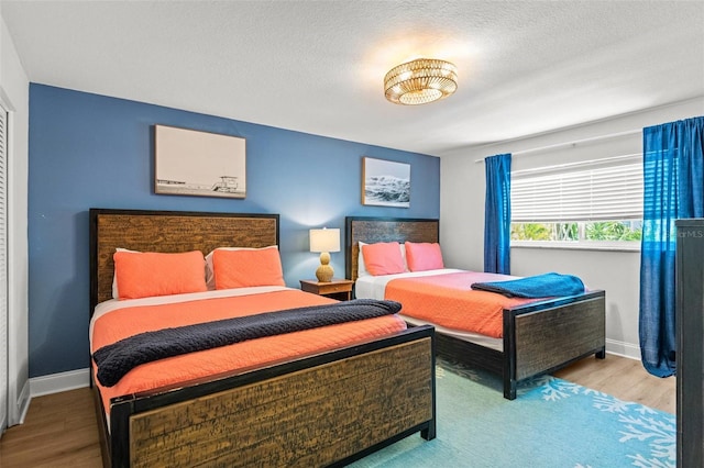 1210 Bay Pine Blvd, Indian Rocks Beach, FL 33785 - bedroom with wood finished floors, baseboards, and a textured ceiling
