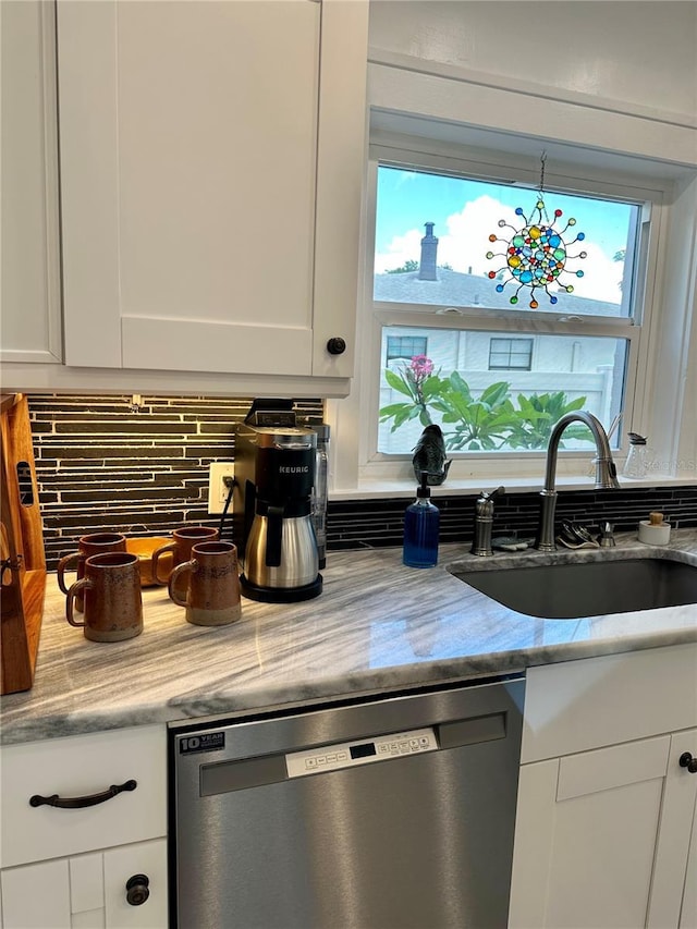 1020 38th Ave N, Saint Petersburg, FL 33704 - kitchen with stainless steel dishwasher, a sink, white cabinets, and tasteful backsplash
