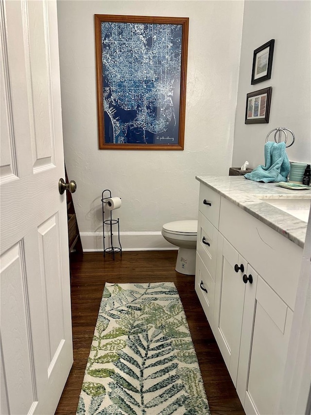 1020 38th Ave N, Saint Petersburg, FL 33704 - bathroom with wood finished floors, toilet, baseboards, and vanity