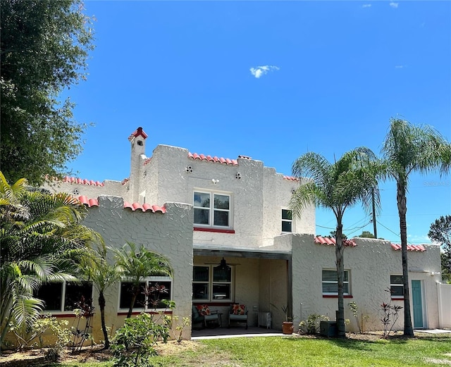 1020 38th Ave N, Saint Petersburg, FL 33704 - rear view of house with stucco siding, a patio, a tile roof, and a chimney