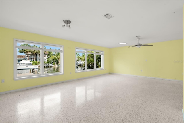 3932 Shore Acres Blvd NE, Saint Petersburg, FL 33703 - unfurnished room with plenty of natural light, ceiling fan, speckled floor, and baseboards