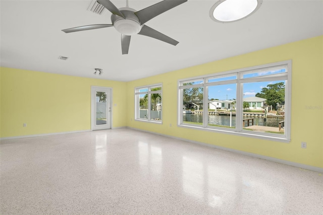 3932 Shore Acres Blvd NE, Saint Petersburg, FL 33703 - spare room with a water view, speckle patterned floor, a ceiling fan, and baseboards