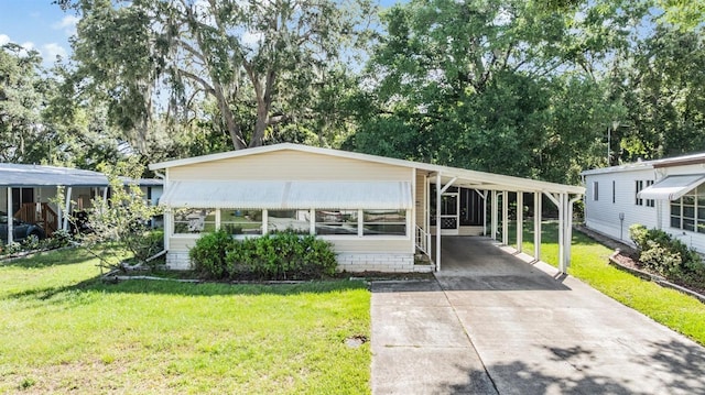 3542 Castle Dr, Zephyrhills, FL 33540 - manufactured / mobile home featuring a front lawn, concrete driveway, and a carport