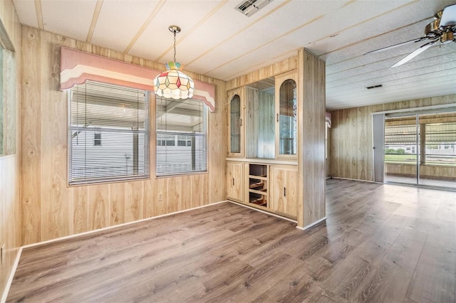 3542 Castle Dr, Zephyrhills, FL 33540 - unfurnished dining area with wood walls, wood finished floors, and a ceiling fan