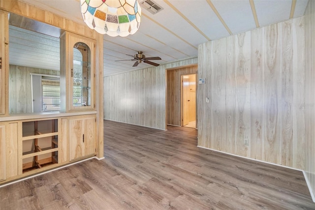 3542 Castle Dr, Zephyrhills, FL 33540 - empty room with wooden walls, wood finished floors, and ceiling fan