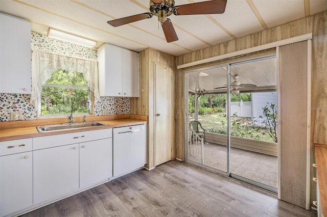 3542 Castle Dr, Zephyrhills, FL 33540 - kitchen with dishwasher, a sink, ceiling fan, healthy amount of natural light, and wooden walls