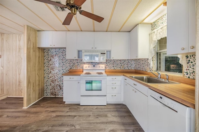 3542 Castle Dr, Zephyrhills, FL 33540 - kitchen featuring white appliances, a sink, ceiling fan, white cabinetry, and wooden walls