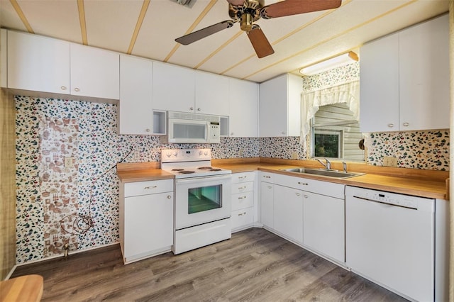 3542 Castle Dr, Zephyrhills, FL 33540 - kitchen with white appliances, a sink, wood counters, light wood-type flooring, and white cabinets