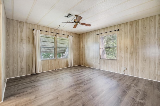 3542 Castle Dr, Zephyrhills, FL 33540 - empty room featuring wood walls, wood finished floors, and ceiling fan
