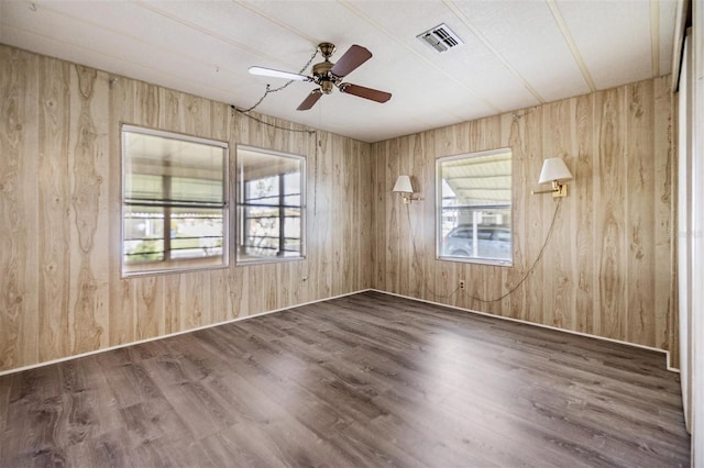 3542 Castle Dr, Zephyrhills, FL 33540 - spare room featuring a ceiling fan, wooden walls, and wood finished floors