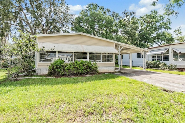 3542 Castle Dr, Zephyrhills, FL 33540 - manufactured / mobile home with a carport, concrete driveway, and a front yard