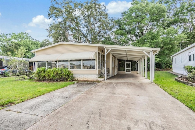 3542 Castle Dr, Zephyrhills, FL 33540 - manufactured / mobile home with concrete driveway, a front lawn, and a carport