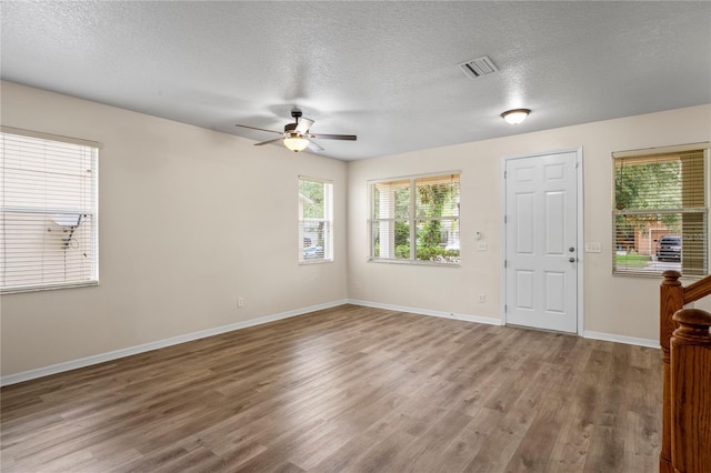 7249 Bridgeview Dr, Wesley Chapel, FL 33545 - foyer entrance featuring ceiling fan, wood finished floors, and a textured ceiling