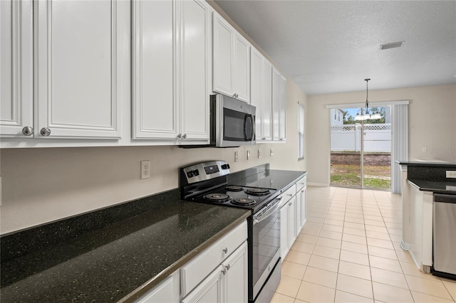 7249 Bridgeview Dr, Wesley Chapel, FL 33545 - kitchen with stainless steel appliances, a chandelier, light tile patterned floors, white cabinets, and hanging light fixtures
