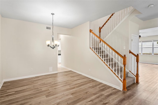 7249 Bridgeview Dr, Wesley Chapel, FL 33545 - staircase featuring wood finished floors, a chandelier, and ceiling fan