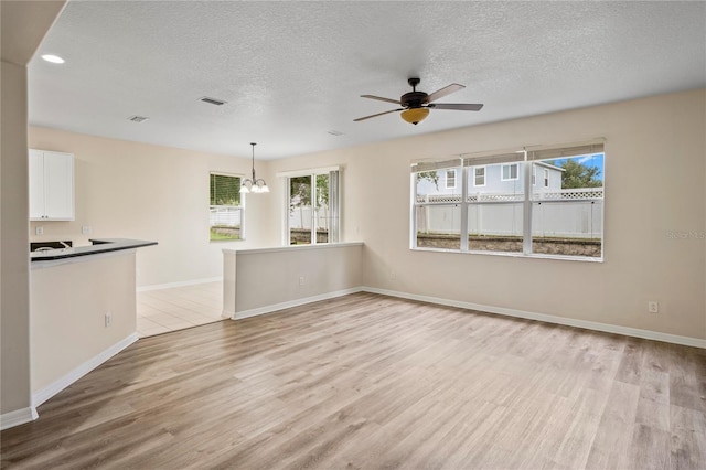 7249 Bridgeview Dr, Wesley Chapel, FL 33545 - unfurnished living room featuring a chandelier, light wood finished floors, a textured ceiling, ceiling fan, and recessed lighting