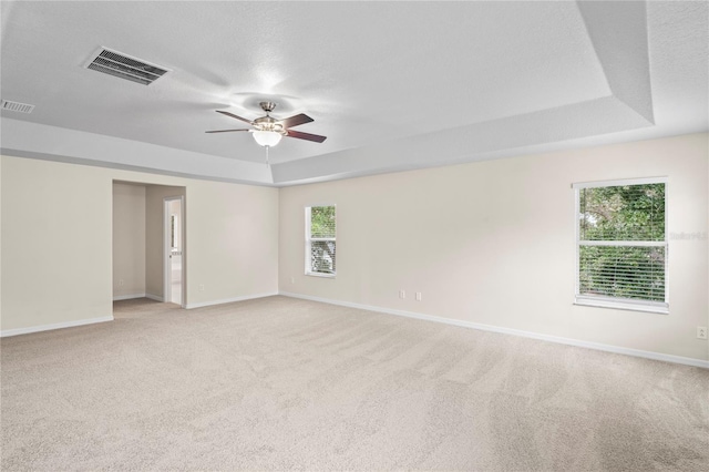 7249 Bridgeview Dr, Wesley Chapel, FL 33545 - empty room with a raised ceiling, ceiling fan, and light carpet