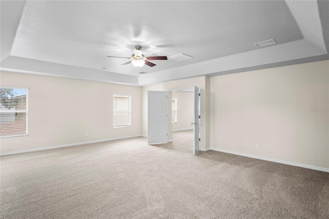 7249 Bridgeview Dr, Wesley Chapel, FL 33545 - spare room featuring a textured ceiling, light colored carpet, plenty of natural light, a ceiling fan, and a raised ceiling