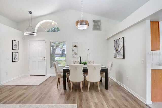 4921 Wessex Way, Land O Lakes, FL 34638 - dining area featuring light wood-style flooring, high vaulted ceiling, and baseboards
