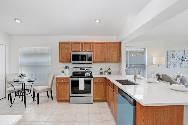 4921 Wessex Way, Land O Lakes, FL 34638 - kitchen featuring stainless steel appliances, a sink, a peninsula, brown cabinets, and healthy amount of natural light