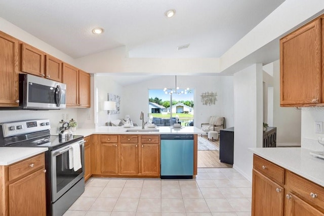 4921 Wessex Way, Land O Lakes, FL 34638 - kitchen featuring appliances with stainless steel finishes, a sink, open floor plan, a peninsula, and light countertops