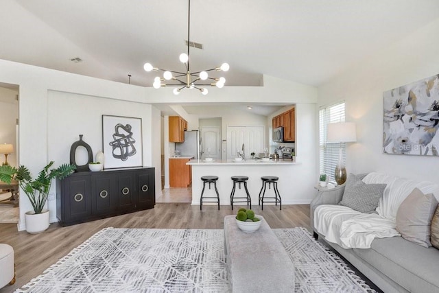 4921 Wessex Way, Land O Lakes, FL 34638 - living room featuring a chandelier, light wood-style flooring, lofted ceiling, and baseboards