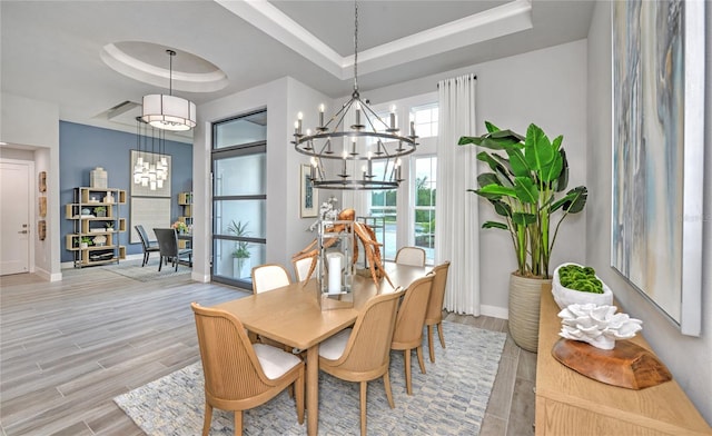 256 Stirling Bridge Dr, Ormond Beach, FL 32174 - dining space featuring a raised ceiling, a chandelier, baseboards, and light wood finished floors