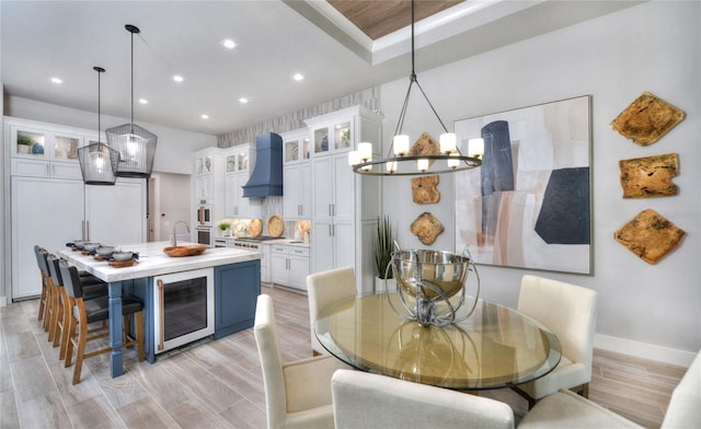 256 Stirling Bridge Dr, Ormond Beach, FL 32174 - kitchen featuring wine cooler, custom exhaust hood, recessed lighting, light countertops, and white cabinets