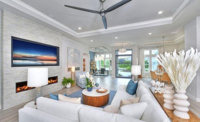 256 Stirling Bridge Dr, Ormond Beach, FL 32174 - living area with a fireplace, wood finished floors, a tray ceiling, ornamental molding, and recessed lighting