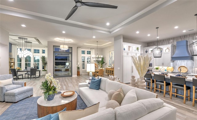 256 Stirling Bridge Dr, Ormond Beach, FL 32174 - living area featuring a chandelier, a ceiling fan, a raised ceiling, light wood-type flooring, and recessed lighting