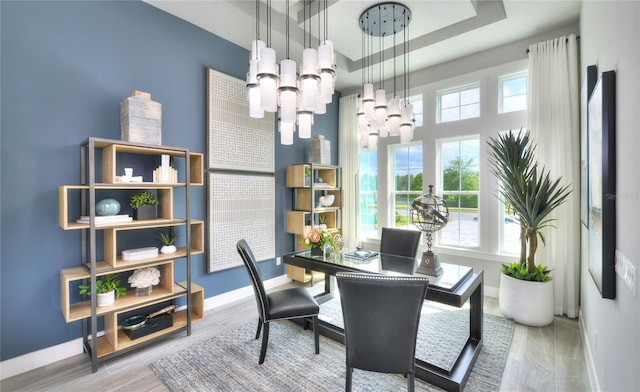 256 Stirling Bridge Dr, Ormond Beach, FL 32174 - dining space with a chandelier, baseboards, a tray ceiling, wood finished floors, and an office area