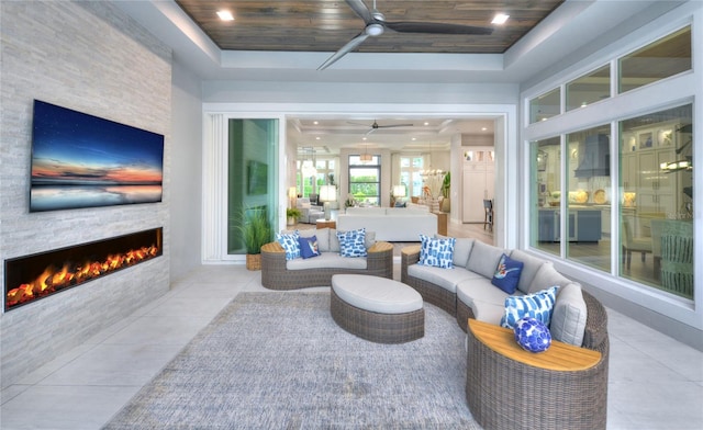256 Stirling Bridge Dr, Ormond Beach, FL 32174 - tiled living room with a ceiling fan, a fireplace, a tray ceiling, and wood ceiling